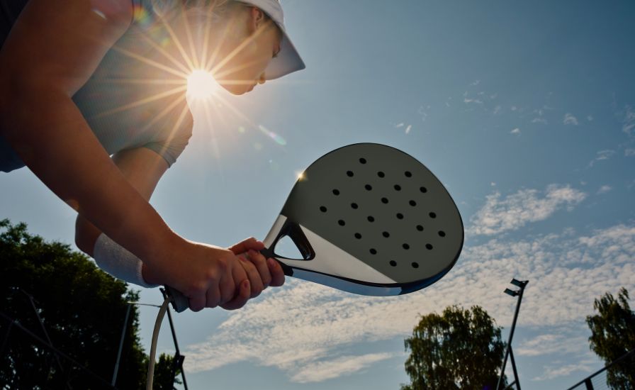 below view of a female padel player holding a racket