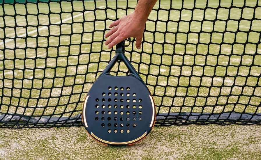 professional padel player getting ready to hold a black padel racket on court