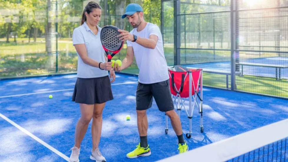 padel coach instructing player on padel rules on court