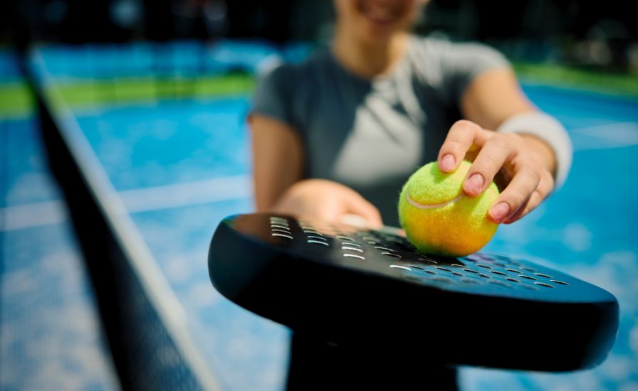 close up of athletic woman with padel racket and ball in hand