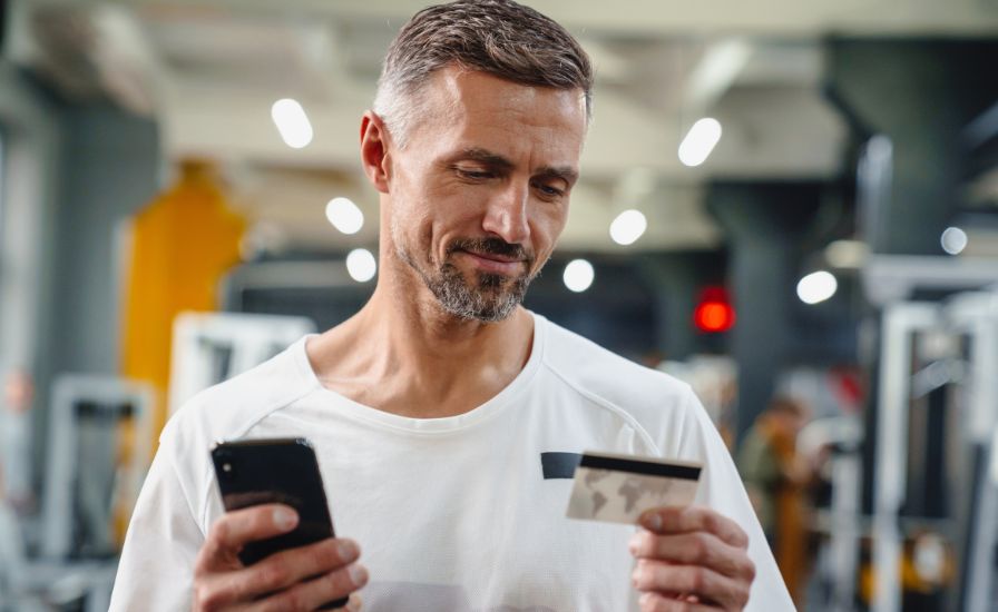 athletic man paying online for tennis and padel equipment, safe payment methods